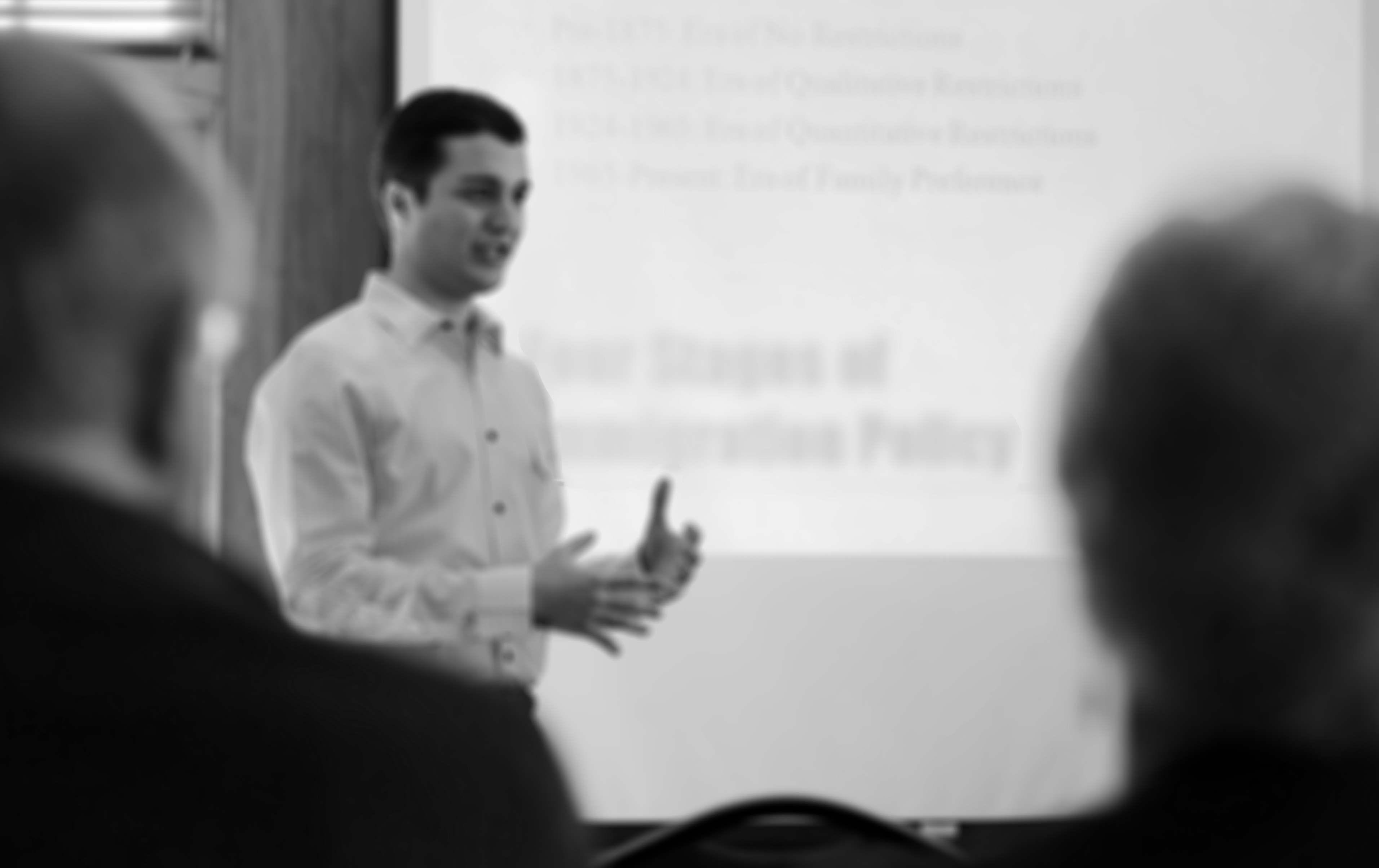 Black and White photo of an undergraduate giving a presentation with slideshow at a UW-Madison symposium