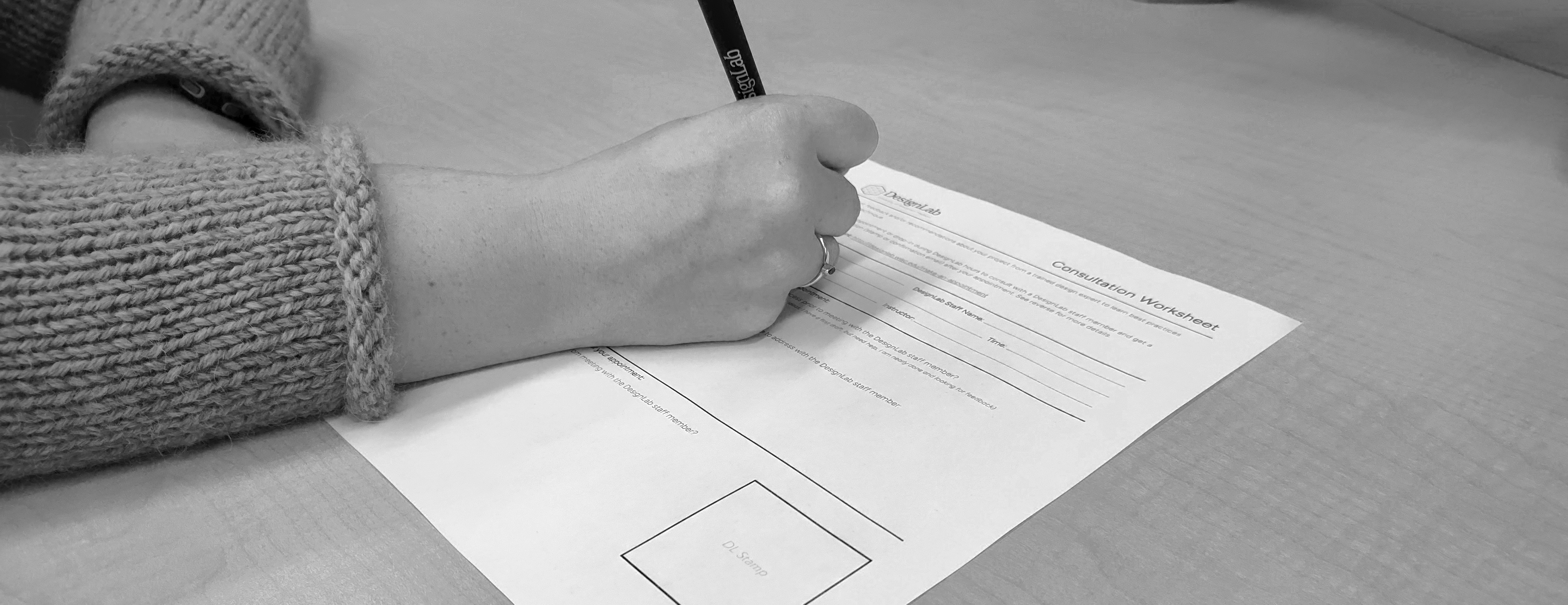 A student filling out a DesignLab consultation worksheet with a DesignLab pen